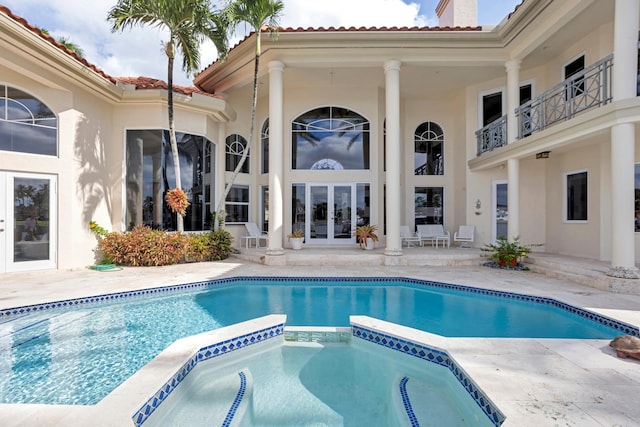 view of pool with an in ground hot tub, a patio, and french doors