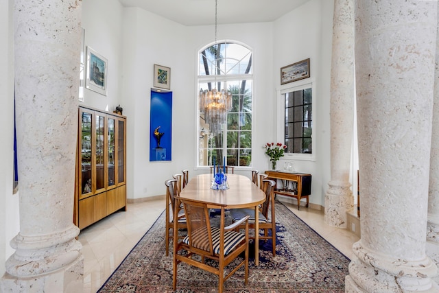 dining room with a towering ceiling, ornate columns, and a notable chandelier