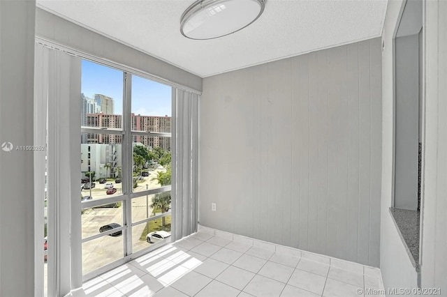 tiled empty room with wooden walls and a textured ceiling