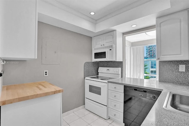 kitchen with white cabinets, ornamental molding, light tile patterned floors, and white appliances