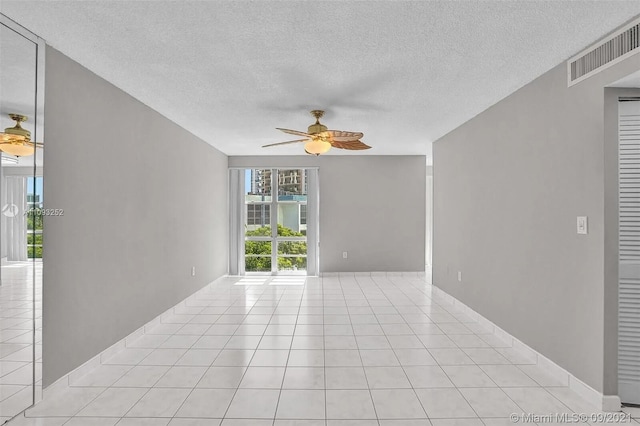 tiled empty room with a textured ceiling and ceiling fan