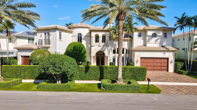 mediterranean / spanish-style house featuring a garage and a balcony