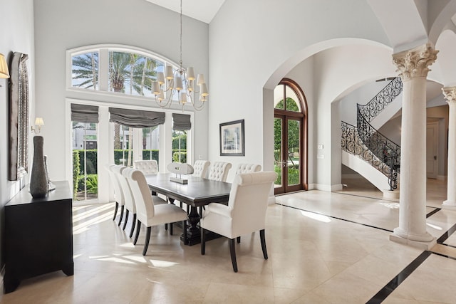 dining space with french doors, ornate columns, a healthy amount of sunlight, an inviting chandelier, and a high ceiling