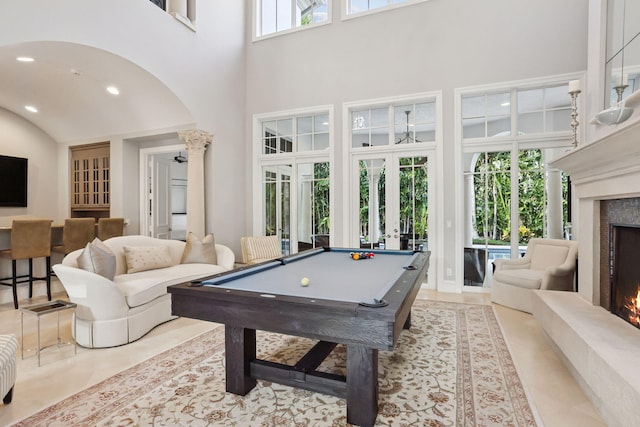 rec room with french doors, a high end fireplace, a high ceiling, and pool table