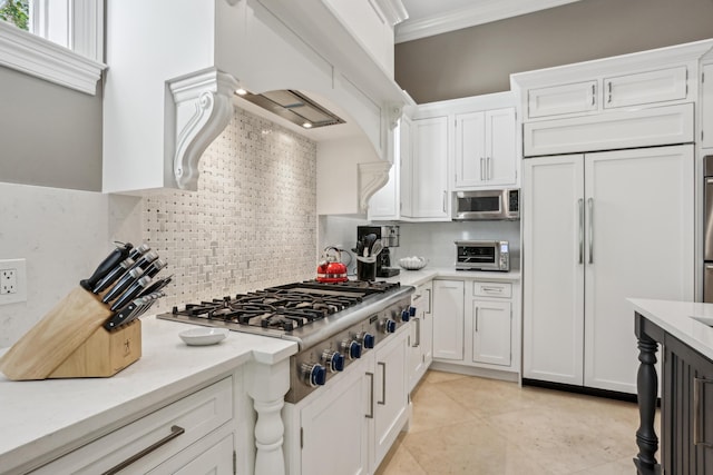 kitchen with decorative backsplash, crown molding, white cabinets, and stainless steel appliances