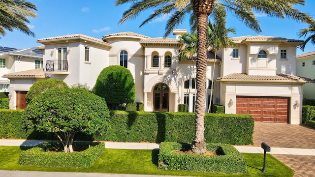 mediterranean / spanish home featuring a garage and a balcony