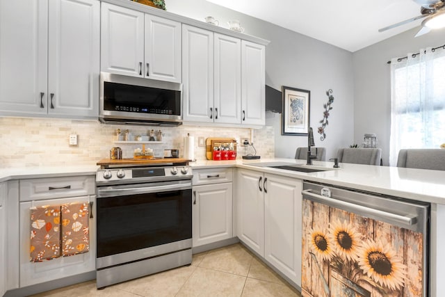 kitchen with white cabinets, sink, light tile patterned floors, and stainless steel appliances