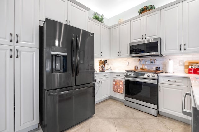 kitchen featuring white cabinets, light tile patterned floors, stainless steel appliances, and tasteful backsplash