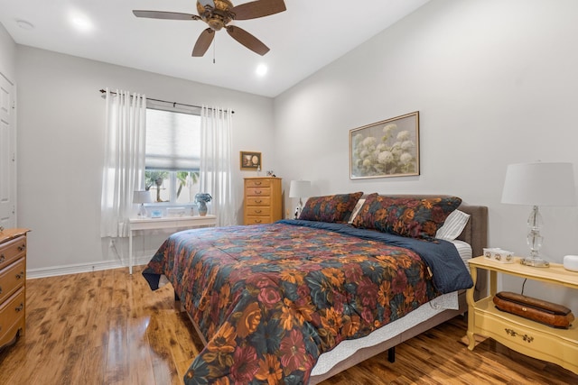 bedroom with light wood-type flooring, vaulted ceiling, and ceiling fan