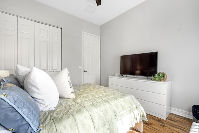 bedroom featuring ceiling fan, dark hardwood / wood-style flooring, and a closet