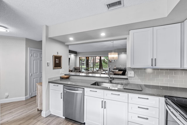 kitchen with white cabinetry, sink, decorative backsplash, stainless steel appliances, and a textured ceiling