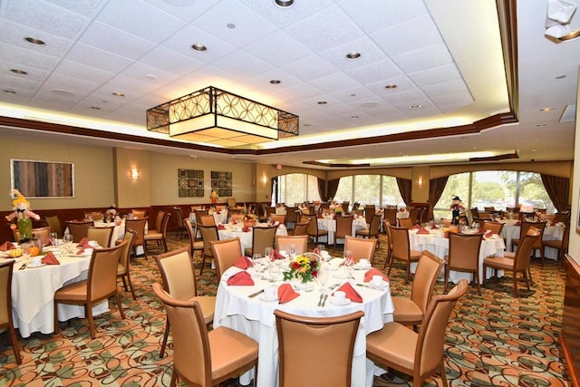 dining area with a paneled ceiling and a raised ceiling