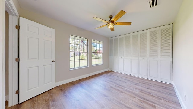 unfurnished bedroom featuring light hardwood / wood-style floors, ceiling fan, and a closet