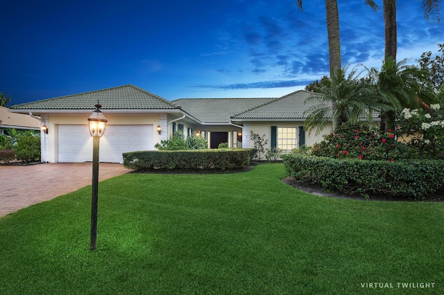 view of front of home with a garage and a yard