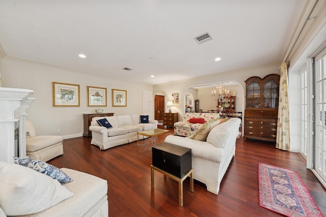 living room featuring ornamental molding, dark hardwood / wood-style flooring, and a notable chandelier