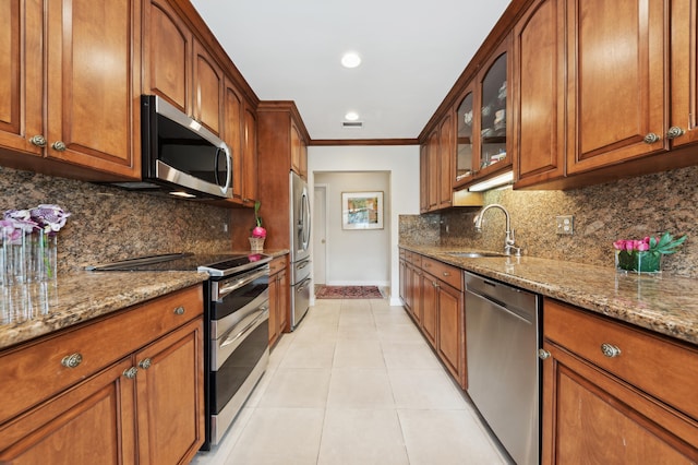 kitchen with tasteful backsplash, light stone counters, sink, and stainless steel appliances