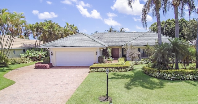 single story home featuring a garage and a front lawn