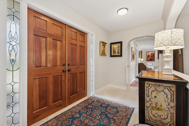 tiled foyer featuring crown molding