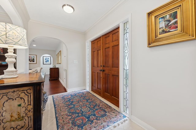 tiled entryway featuring ornamental molding