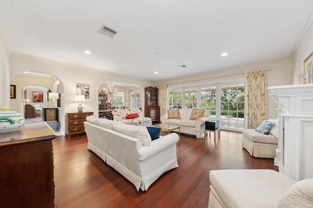 living room featuring dark hardwood / wood-style floors, crown molding, and an inviting chandelier