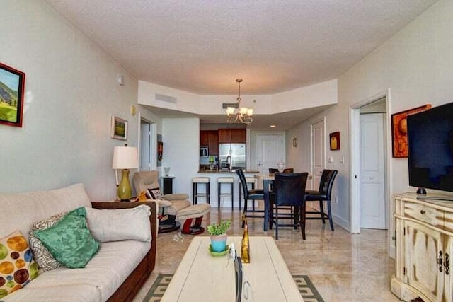 living room featuring a textured ceiling and a notable chandelier