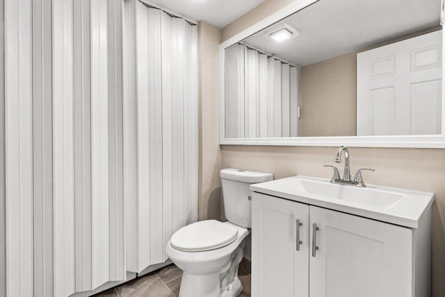 bathroom featuring tile patterned flooring, vanity, and toilet