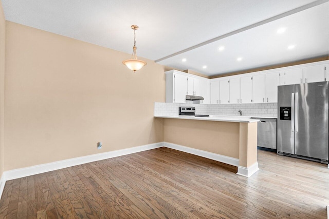 kitchen featuring pendant lighting, white cabinets, light wood-type flooring, appliances with stainless steel finishes, and kitchen peninsula