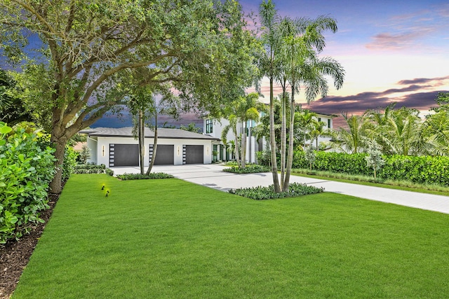 view of front of property with a garage and a yard