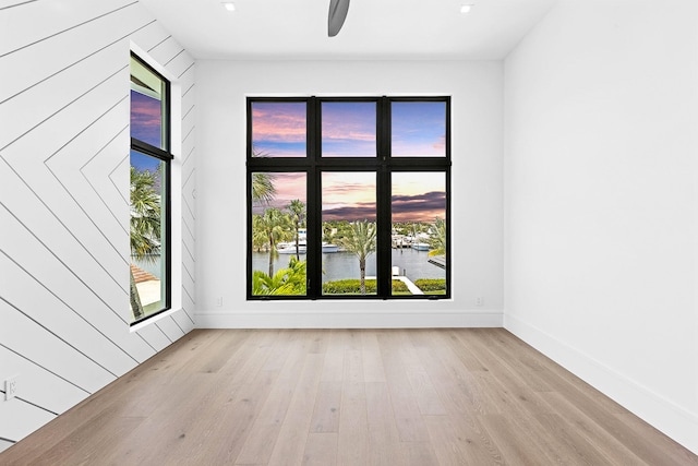 empty room featuring light hardwood / wood-style floors and a water view