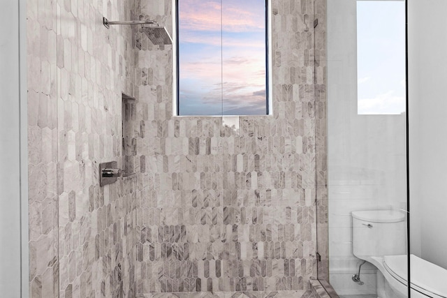 bathroom featuring toilet and tiled shower