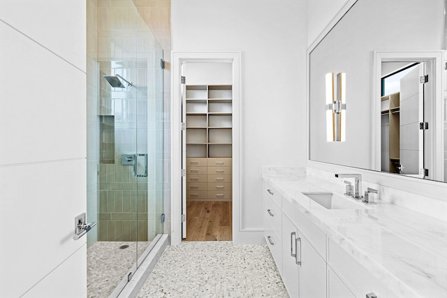 bathroom with hardwood / wood-style floors, a shower with door, and vanity