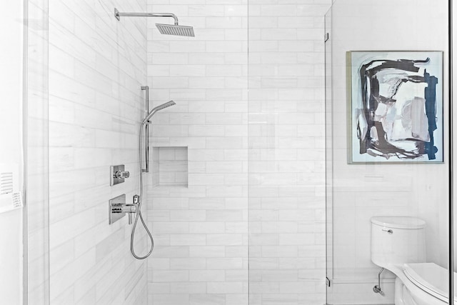 bathroom with tiled shower and toilet