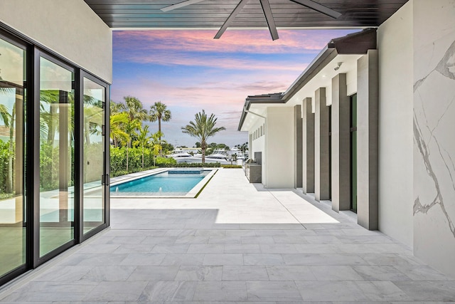 pool at dusk with a patio area