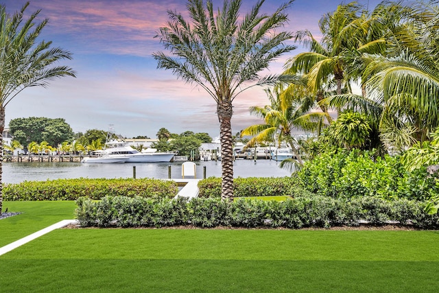 surrounding community featuring a water view and a lawn