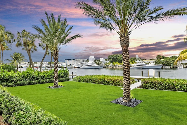 yard at dusk featuring a water view