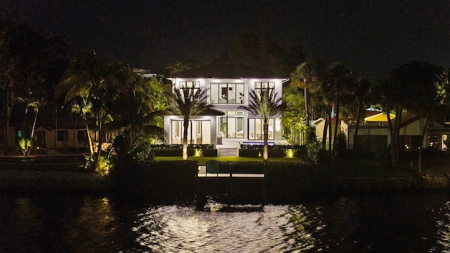 back house at twilight with a water view