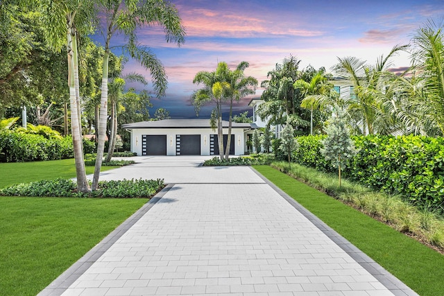 view of front of house with a garage and a yard