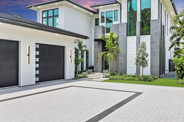 exterior entry at dusk with a garage