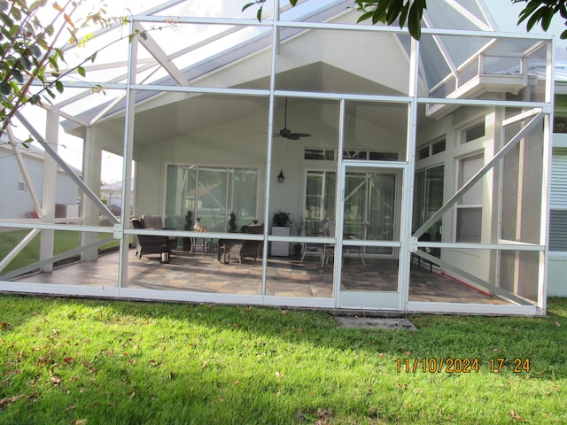 back of house with a lawn, a patio, ceiling fan, and glass enclosure