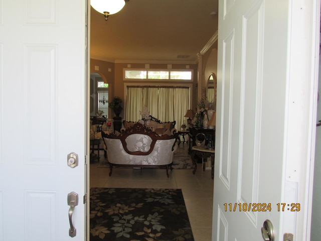 hallway with ornamental molding and tile patterned flooring