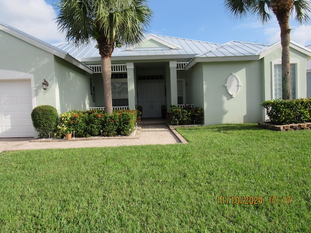 view of exterior entry featuring a garage and a lawn