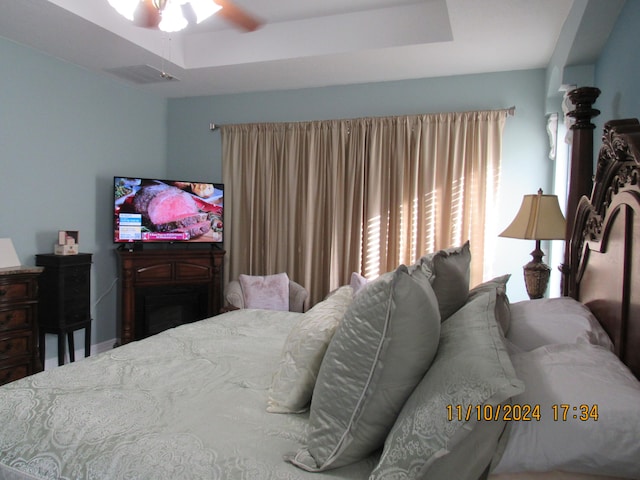 bedroom featuring ceiling fan and a tray ceiling