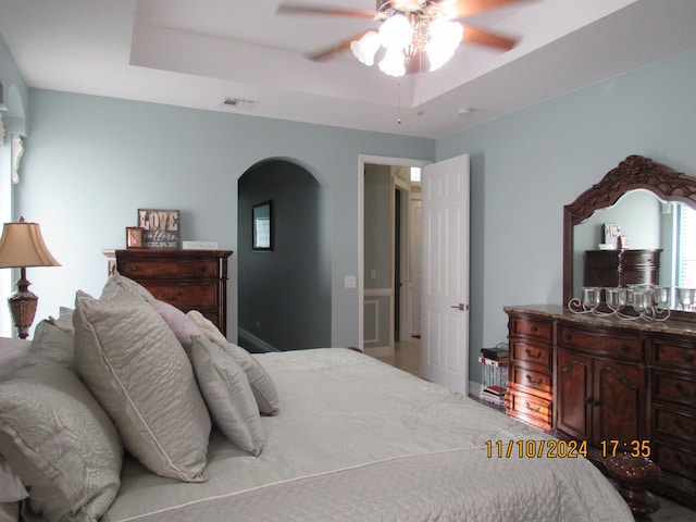 bedroom featuring ceiling fan, a raised ceiling, and carpet floors