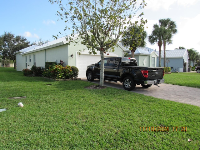 view of side of home featuring a garage and a yard