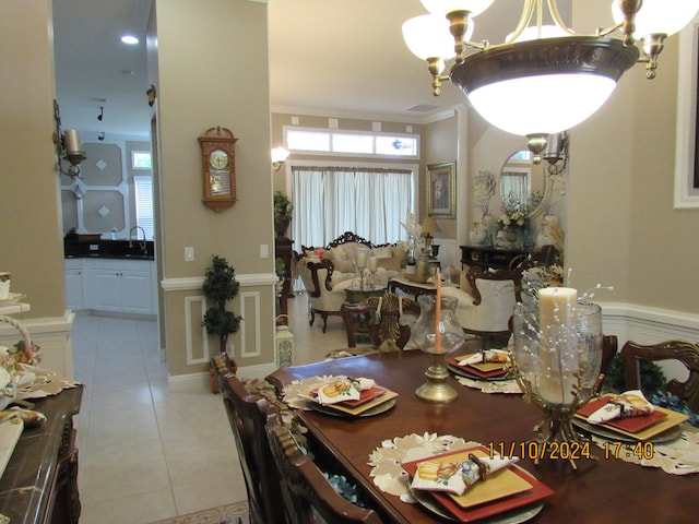 dining room with crown molding, light tile patterned floors, and sink