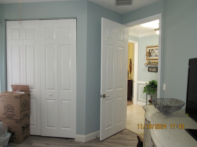 bedroom featuring a closet, ornamental molding, and light hardwood / wood-style flooring