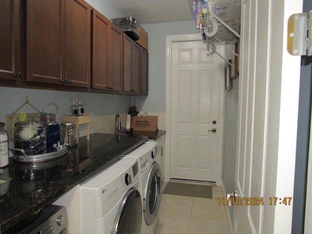 laundry room featuring cabinets, light tile patterned flooring, and washer and dryer