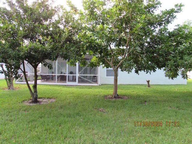 view of yard featuring glass enclosure and a patio