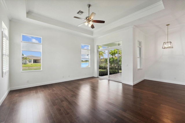 spare room with dark hardwood / wood-style flooring, a tray ceiling, ornamental molding, and ceiling fan with notable chandelier