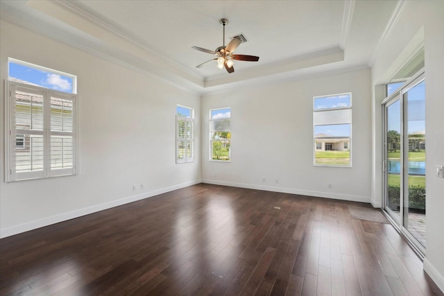 empty room featuring dark hardwood / wood-style flooring, a raised ceiling, ceiling fan, and crown molding